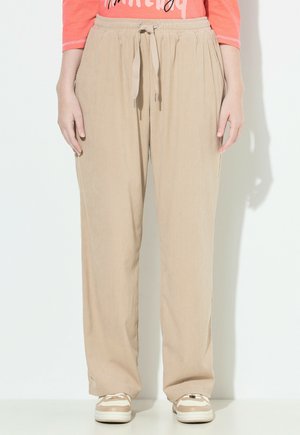 Beige ribbed corduroy-housut, joissa on joustava nauhavyötärö, sivutaskut ja läpäisevä malli, yhdistettynä vaaleisiin lenkkareihin.