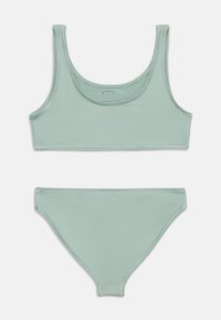 Πράσινο ανοιχτό πράσινο τοπ μπικίνι με λαιμόκοψη scoop και ταίριαστο κάτω μέρος μπικίνι με χαμηλή μέση, απλωμένα σε λευκό φόντο.