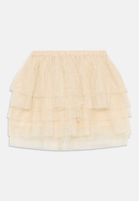 Beige lagdelt tyll miniskjørt med glitterdetaljer og elastisk midjebånd på hvit bakgrunn.