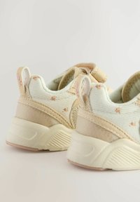 Sko med en lys mintgrøn canvasoverdel, beige detaljer, tekstureret materiale og dekorativ syning. Inkluderer hælstræk.