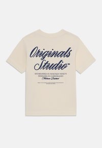 Cream cotton t-shirt featuring navy printed text on the back, with round neckline and short sleeves. Minimalist design with no patterns.