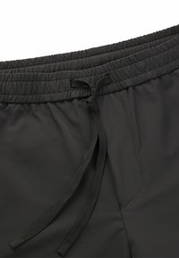 Schwarze sportliche Shorts mit elastischem Taillengummi, verstellbarem Kordelzug und glattem, leichtem Stoff mit einer dezenten Textur.