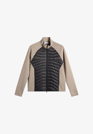 Veste beige et noire à fermeture éclair complète avec un panneau avant matelassé noir et des manches et épaules beiges lisses, col montant, sans logos visibles.