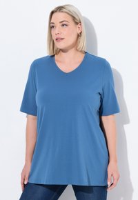 T-shirt blu a scollatura a V realizzata in tessuto morbido, con maniche corte e vestibilità rilassata. Texture liscia, senza motivi o accenti visibili.