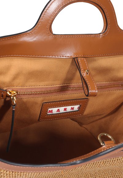 Interno di una borsa a mano in pelle marrone con rivestimento in tessuto texture, tasca interna con zip, e un'etichetta con "MARNI" in rosso su uno sfondo bianco.