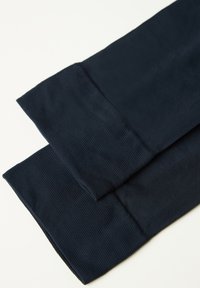 Mörk marinblått tyg med en slät yta och ribbade detaljer vid ärmsluten. Två vikta delar som visar en ren, minimalistisk design.
