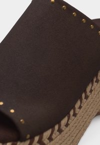 Ταμπά γυναικείο πέδιλο πλατφόρμα με χρυσά τρουκς και πλεκτή μπεζ σόλα, απεικονίζεται με λεπτομέρεια από το πλάι.