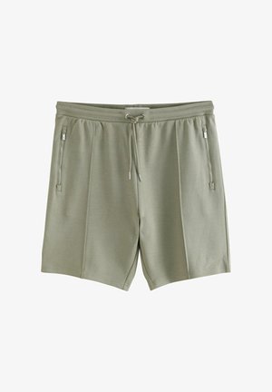 Svetlozeleni šortsi narejeni iz mehkega materiala z elastičnim pasom, vrvico in dvema stranskima žepoma z zadrgo.