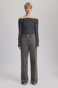 Langermet topp uten skuldre i mørk grå, kombinert med løse, høyt liv, grå denimjeans med detaljer på siden og knappelukking.