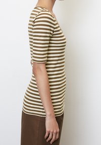 Pruhované krátké rukávy top v krémové a hnědé bavlně. Má kulatý výstřih a přiléhavý střih, s horizontálními pruhy a hladkou texturou.