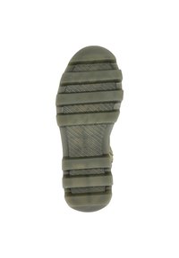 Suela de zapato de goma verde con ranuras horizontales y verticales, con crestas elevadas para tracción. Tacón redondo y un logo grabado en el centro.