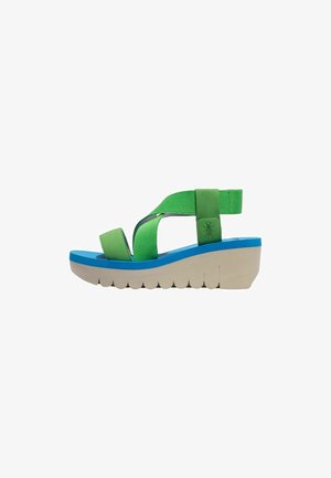 Sandalias de tela verde con tacón de cuña que presentan acentos azules, una suela con un diseño de ondas único y correas ajustables para mayor comodidad.