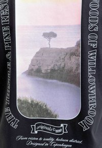 Μονήρες δέντρο πάνω σε βραχώδη γκρεμό με θέα τον ομιχλώδη ωκεανό κατά την ανατολή ή τη δύση του ήλιου, πλαισιωμένο από στυλιζαρισμένο κείμενο σε μαύρο φόντο.