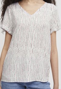 Top a maniche corte, con scollo a V, realizzato in un tessuto leggero e caratterizzato da righe verticali rosa, nere e blu su sfondo bianco. Vestibilità casual.