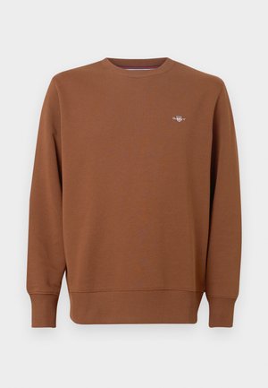 Brun crewneck-sweatshirt i blødt materiale med lange ærmer og et lille broderet logo på brystet. Ribstrikkede manchetter og kant.