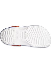 Suola in gomma bianca di una scarpa Crocs con un motivo di presa testurizzato, dotata di un bordo blu e un accento arancione nella zona del tallone.