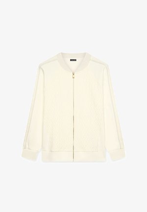 Chaqueta cremera con cremallera con un frente de punto de cable texturizado, mangas lisas, puños acanalados y una cremallera dorada para el cierre.