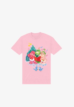 T-shirt en coton rose présentant trois ours en dessin animé chantant autour d'un sapin de Noël, avec des notes de musique colorées et des rossignols en dessous.