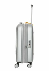 Valigia rigida argento con manico telescopico, doppie ruote, chiusura a zip e lucchetto a combinazione. Presenta una linguetta di accento gialla.