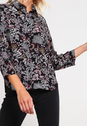 Sort bluse med et blomstermønster i nuancer af pink og hvid, med kraveudskæring og 3/4 ærmer, lavet af letvægtsstof.