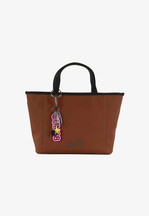 Bolsa de tote marrón con asas negras, triángulo negro y logotipo en forma de X, y llavero colorido que presenta números rosas, una estrella amarilla y un corazón negro.