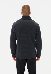 Donkergrijze pullover met een gestructureerd, geweven patroon. Heeft een hoge kraag en lange mouwen. Gemaakt van een zachte stof, geschikt voor het lagen van kleding.