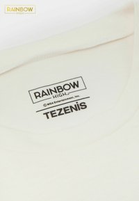 Bílý bavlněný tričko s kulatým výstřihem. Na štítku jsou zahrnuty detaily "RAINBOW HIGH," "TEZENIS" a logo v černém písmu.