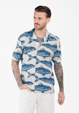 Korte mouwen overhemd van lichtbeige stof met een blauw vispatroon. Opvallende details zijn de kraag en de losse pasvorm.
