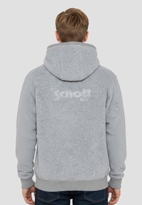 Grijze capuchontrui met een gestructureerd oppervlak, voorzien van een frontale kangeroezak en geribbelde manchetten, met een licht logo op de achterkant.