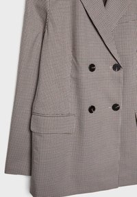 Dvojak u crno-smešnom houndstooth uzorku, sa crnim dugmadi, širokim reverima i bočnim džepovima. Teksturirana tkanina.