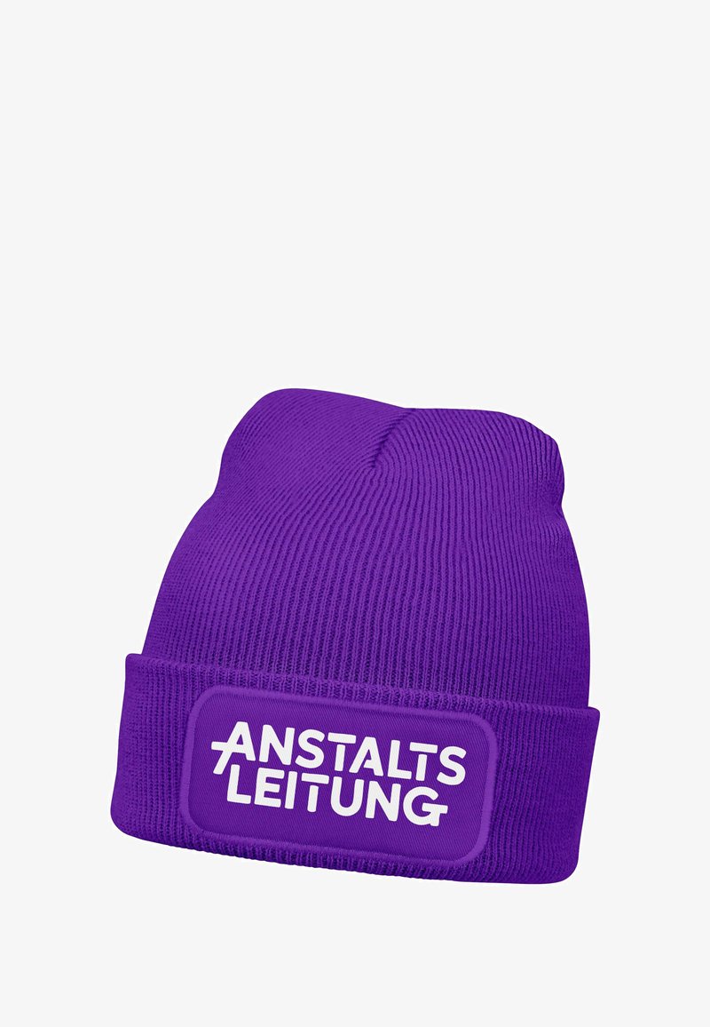 Purple knitted beanie featuring a thick ribbed texture and a rectangular patch with white text "ANSTALTSLEITUNG" on the front.