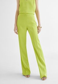 Ljusgrön vida byxor i mjukt tyg med en åtsittande midja, som har sidofållar och en dold framknäppning.