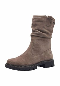 Bottine en daim marron avec une tige flasque, des coutures contrastantes, une surface texturée et une semelle épaisse en caoutchouc noir.