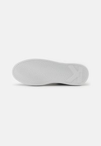 Witte sneakerzool met golfpatroon. Voorzien van textuurrubber voor grip. Minimalistisch ontwerp met logo-detail aan de zijkant.