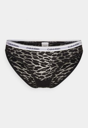 Black lace briefs with a decorative pattern, featuring a white Calvin Klein logo waistband and smooth texture. Classic bikini cut design.