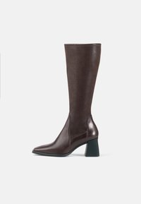 Brown leather knee-high boot with a pointed toe, smooth texture, and a chunky black heel. Seamless design with minimal accents.