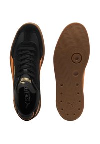 Scarpe da ginnastica nere con accenti arancioni, parte superiore in pelle testurizzata e mesh, suola in gomma con motivo ondulato e dettaglio circolare centrale.