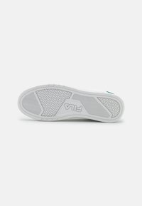 Sole di scarpa bianca con un motivo di presa testurizzato, caratterizzata da dettagli del logo in rilievo e un accento contrastante in teal. Materiale in gomma resistente.