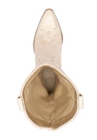 Bota de tobillo de ante beige con punta afilada, patrón floral en relieve, acentos dorados alrededor del cuello y forro interior suave.