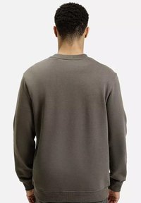 Szary sweter z okrągłym dekoltem, długimi rękawami i ściągaczami. Miękka tekstura z luźnym krojem i minimalnymi detalami w szwach.