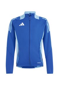 Blauwe sportjack met lichterblauwe accenten, volledige rits aan de voorkant, hoge kraag en meshdetails aan de zijkanten. Beschikt over drie strepen op de schouders.