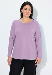 Lavendel-langärmliges T-Shirt mit Rundhalsausschnitt, aus weichem Stoff gefertigt. Kombiniert mit schwarzen Hosen, bietet einen entspannten Schnitt.