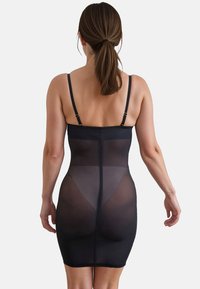 Abito modellante nero con spalline regolabili, pannello posteriore trasparente, design aderente e texture liscia, che arriva fino a metà coscia.