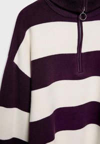 Pull à rayures avec col haut. Présente de larges rayures pourpres foncées et crème, une fermeture éclair demi-zip à l'avant avec une quincaillerie en métal, et une texture en tricot douce.