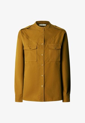 Chemise à manches longues en coton jaune moutarde avec boutons. Comprend deux poches poitrine, des boutons dorés et un col montant avec des épaulettes.