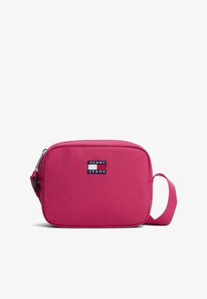Lille rektangulær lyserød stof crossbody taske med en enkelt strop og et Tommy Jeans logo patch foran.