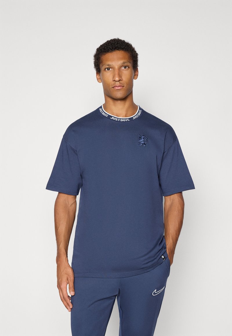 Marineblå bomulds t-shirt med korte ærmer, ribbet rund halsudskæring med "JUST DO IT" tekst og et tonet broderet logo på brystet.