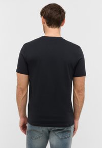 Czarny bawełniany t-shirt z krótkim rękawem i okrągłym dekoltem, widok z tyłu. Gładka faktura, dopasowany krój, minimalne detale.