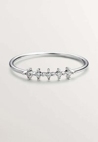 Anillo de plata con cinco pequeñas piedras preciosas transparentes espaciadas uniformemente a lo largo de la banda, que presenta un acabado suave y pulido y un diseño delicado.