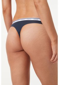 String en coton bleu marine avec une taille élastique blanche arborant le logo "next". Le design est minimaliste avec une texture lisse.